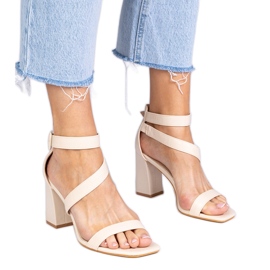 Beige sandaler på stolpen med ett spänne