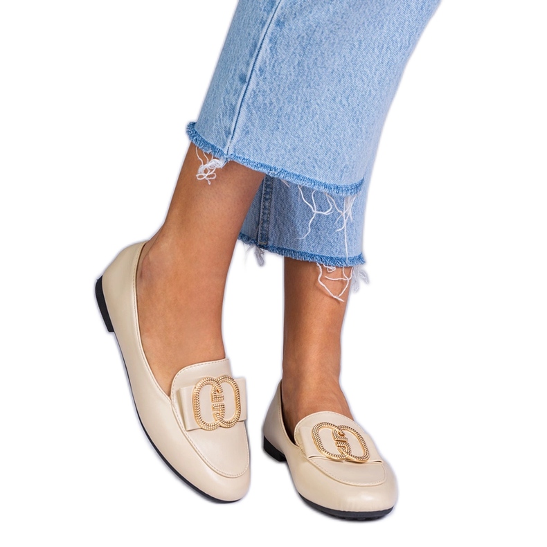 Beige kvinnors loafers med en gyllene dekoration