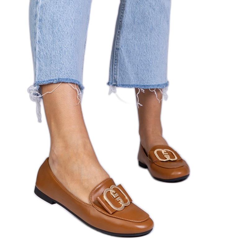 Bruna kvinnors loafers med en gyllene dekoration