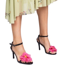 Svarta sandaler på en häl dekorerade med en blomma