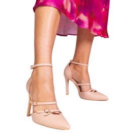 Beige pumpar på en hög häl fäst runt vristen