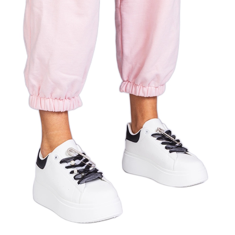 Vita sneakers med en svart insats och en zirkonstift