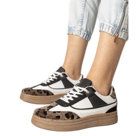 Svartvita sneakers med ett leopardtillbehör