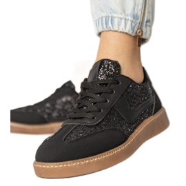Svarta kvinnors sneakers dekorerade med glitter