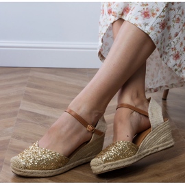 Gyllene brokadesandaler på en kil