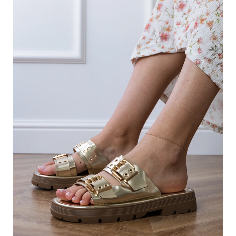 Gyllene platt flip flops med klämmor på ränder