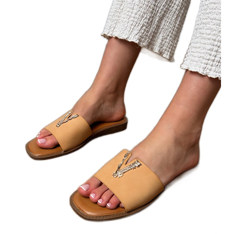 Beige flip flops med en gyllene dekoration