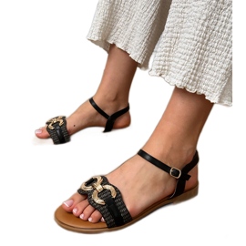 Svarta platta sandaler med en gyllene dekoration