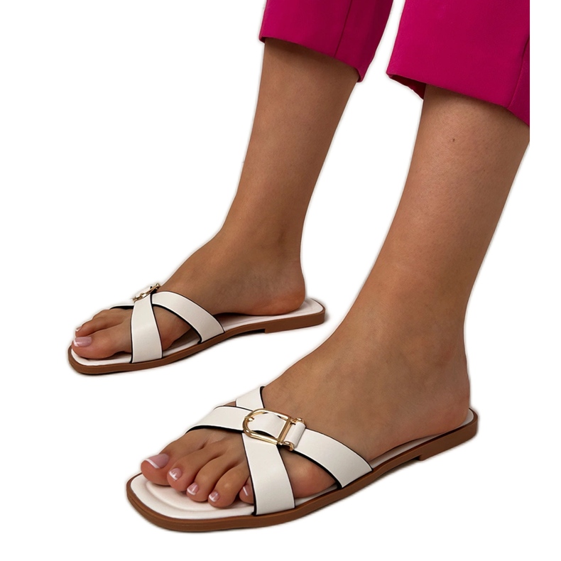 Vita flip flops med ett dekorativt spänne på bältet