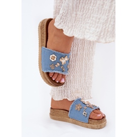 Kvinnors tofflor med gyllene stift på den blå plattformen