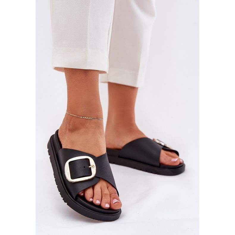 Kvinnors flip flops på plattformen med en gyllene klämma svart