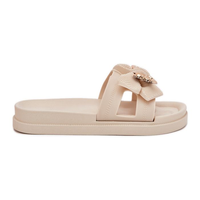 Kvinnors flip flops med en båge och en gyllene ljuskokt brosch beige