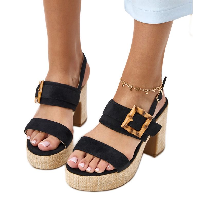 Svarta sandaler på stolpen dekorerade med Elevira Clamp