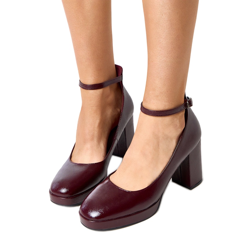 Bourgogne -pumpar lackade på en massiv batuma -post röd