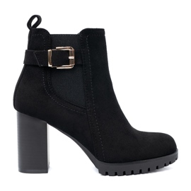 Shelvt Svarta stövlar på stolpen med en dekorativ klämma