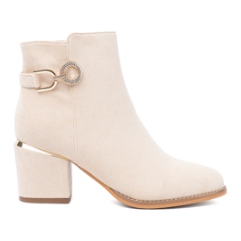 Shelvt Lätt beige stövlar på stolpen med en dekorativ klämma