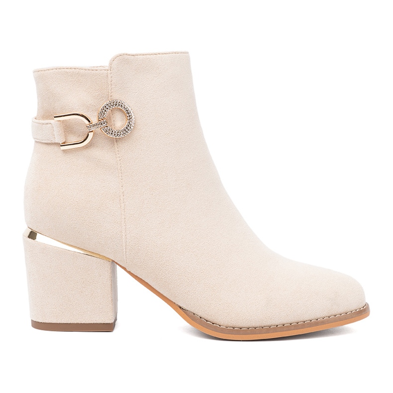 Shelvt Lätt beige stövlar på stolpen med en dekorativ klämma