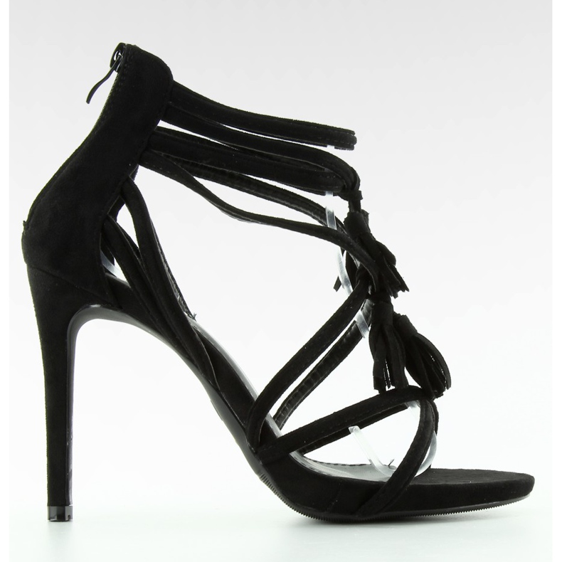 Svarta sandaler på en hög klack med tofsar