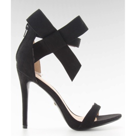 Svarta sandaler på en stift med en svart rosett