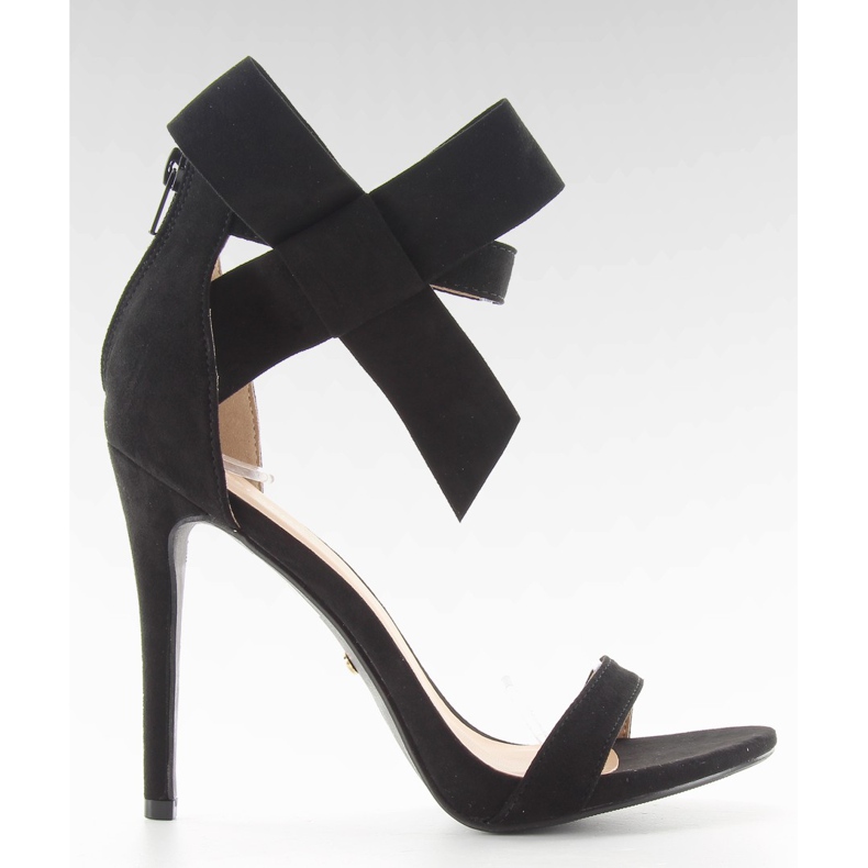 Svarta sandaler på en stift med en svart rosett