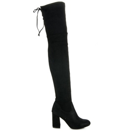 Svarta lårhöga stövlar på ett inlägg