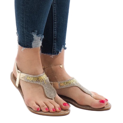 Gyllene flip-flops dekorerade med B012