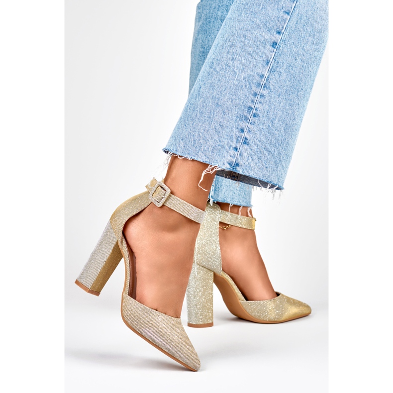 Guldbrokadpumpar fästa på ankeln gyllene 1