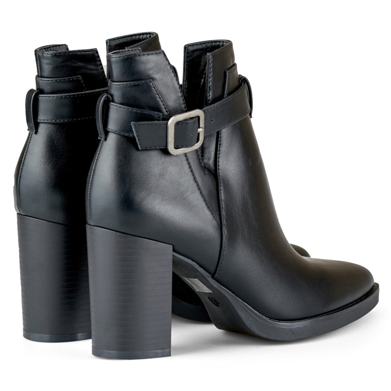 Kvinnors utskurna svarta stövlar på en stolpe beige 1