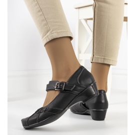 Svarta pumps fästa med ett Gomez-bälte 2