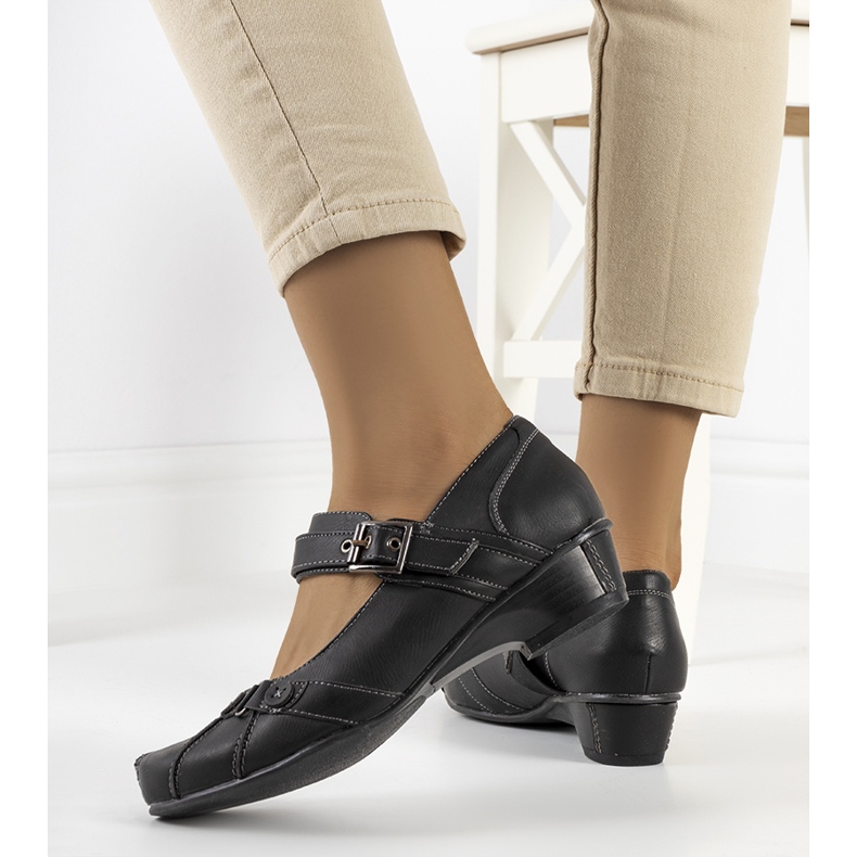 Svarta pumps fästa med ett Gomez-bälte 2