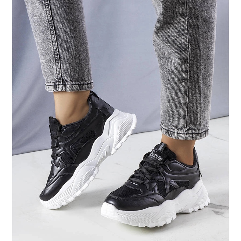 Svarta sneakers på en massiv Lorene-sula 1