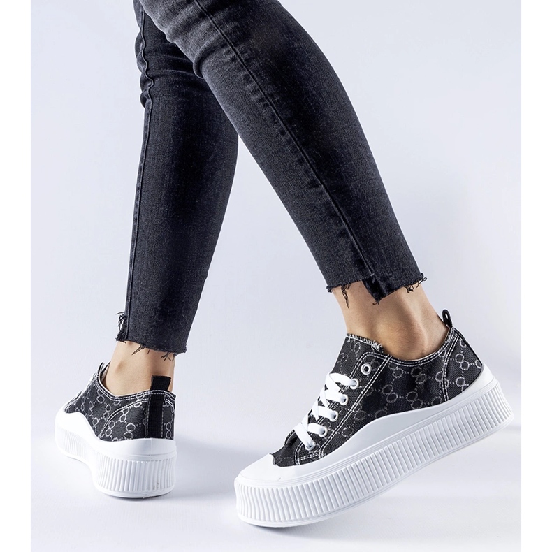 Svarta sneakers dekorerade med Cavi-monogrammet 1