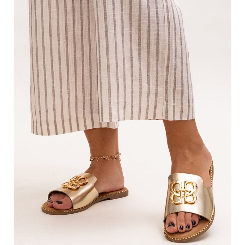 Guldflipflops dekorerade med ett Perkin-spänne gyllene 1