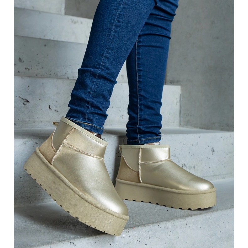 Gyllene låga snöstövlar på plattformen 1