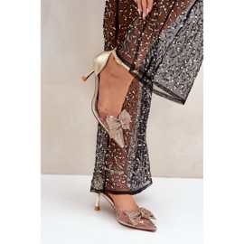 Kvinnors höga klackar dekorerade med en imponerande guldrosett gyllene 1