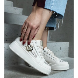 Beige sneakers dekorerade med en lapp och inskriptioner på Etara-plattformen 2