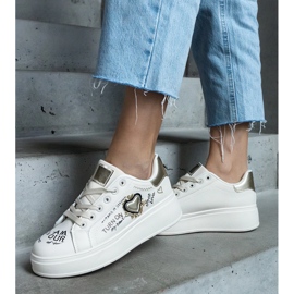 Beige sneakers dekorerade med en lapp och inskriptioner på Etara-plattformen 1