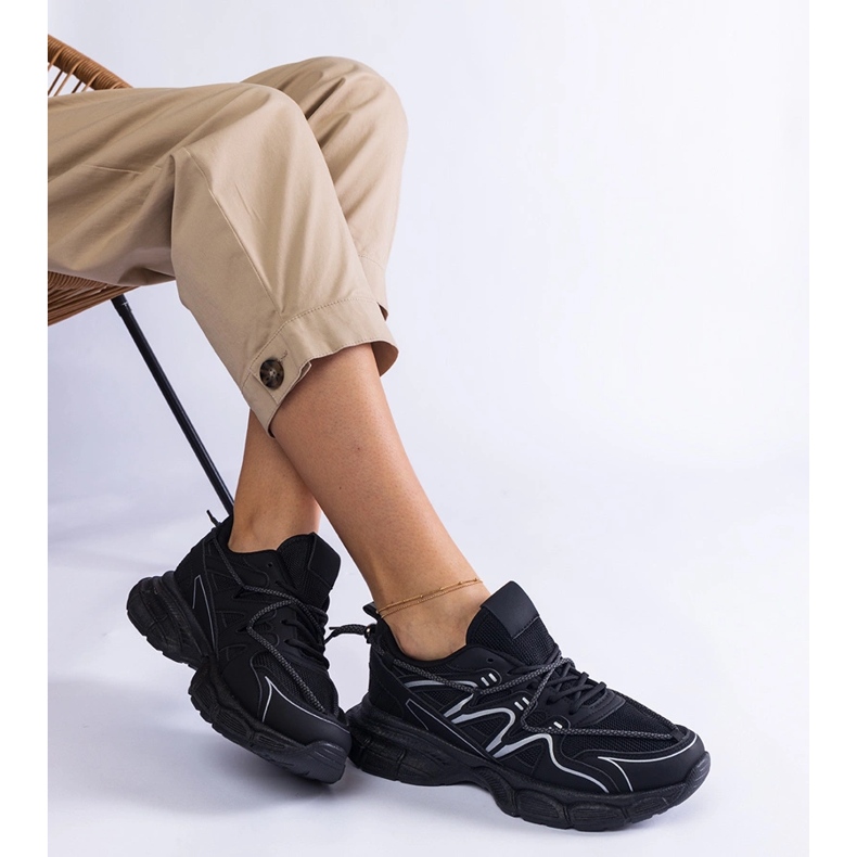 Svarta kvinnors sneakers på en massiv sula 2