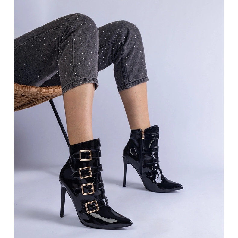 Svarta stövlar lackade på en stift med spännen 1