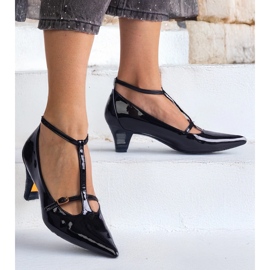 Svarta pumpar lackade på en låg hög med spännen 1