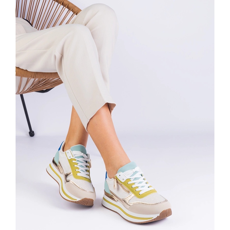 Gröna sportsneakers på plattformen med en gyllene införande 2