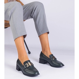 Gröna skor på en låg stolpe med en metallisk dekoration 1