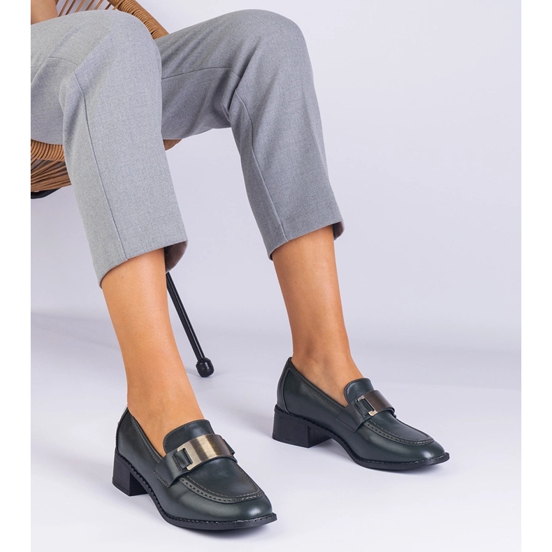 Gröna skor på en låg stolpe med en metallisk dekoration 1