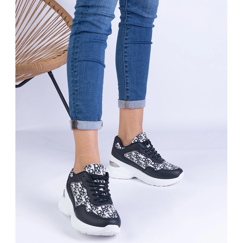 Svarta kvinnors sportsneakers med en metallisk införande 1