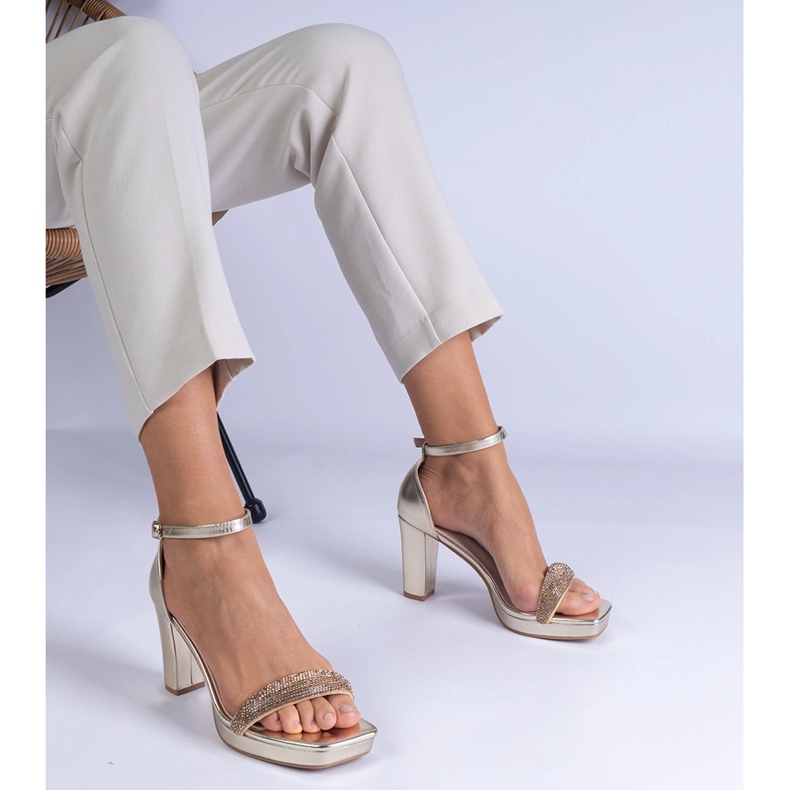 Gyllene eleganta sandaler på pelaren med zirkoner 1