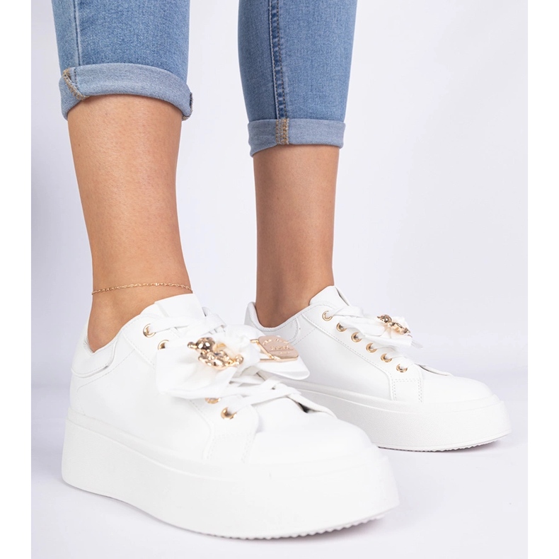 Vita sneakers dekorerade med en båge och en gyllene nallebjörn 1