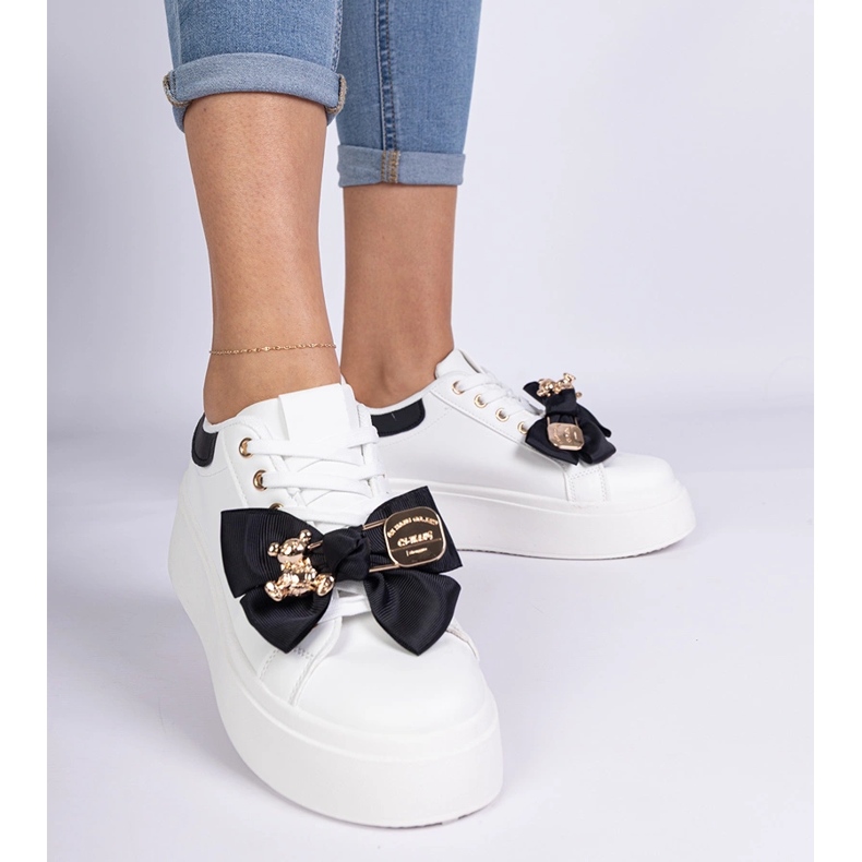 Svarta sneakers dekorerade med en båge och en gyllene nallebjörn 1