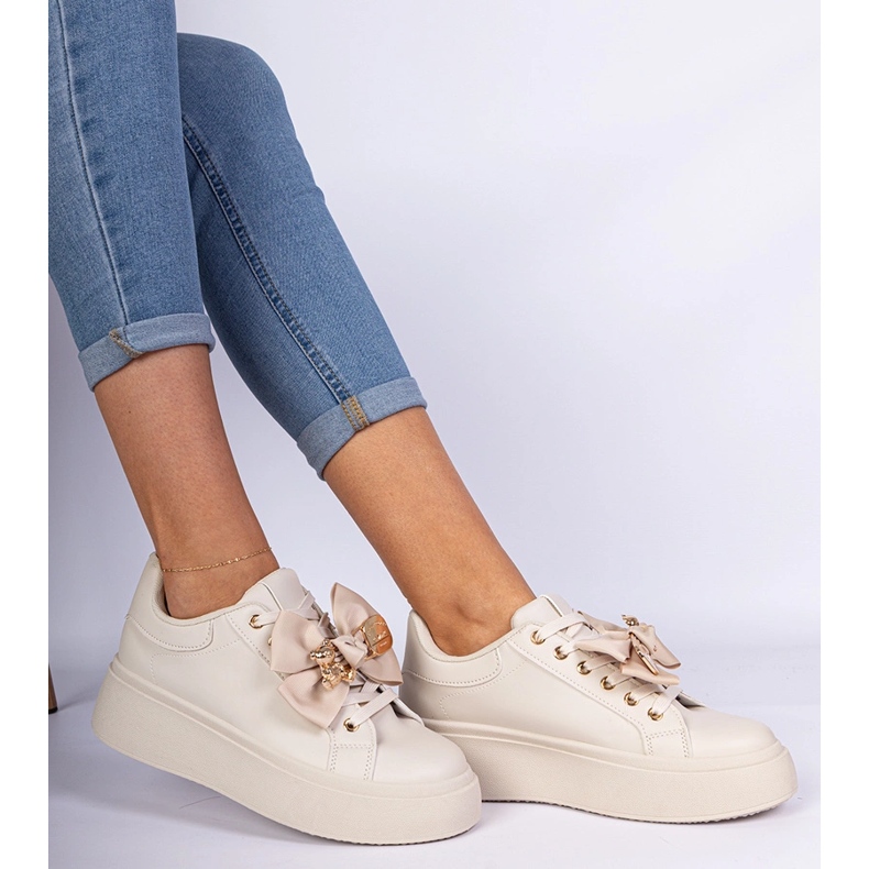 Beige sneakers dekorerade med en båge och en gyllene nallebjörn 1