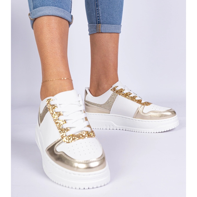 Gyllene kvinnors sneakers på en tjock sula dekorerad med glitter 1