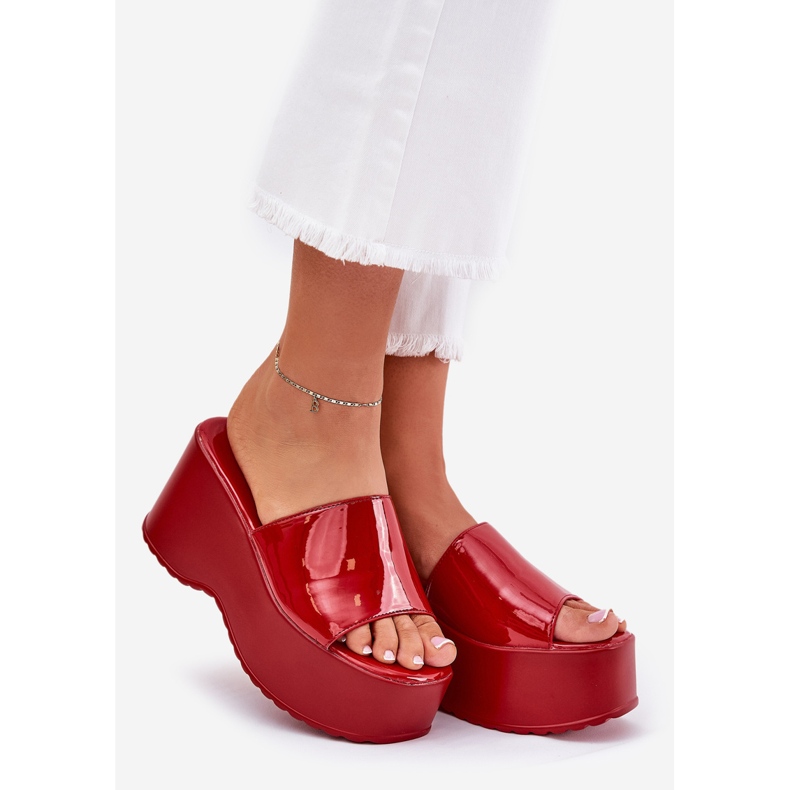 Målade kvinnliga tofflor på plattformen och röda kilar 1